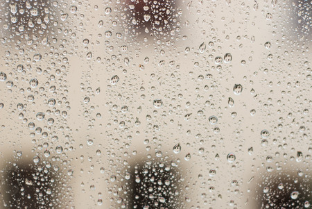 Raindrops on window, city as a background