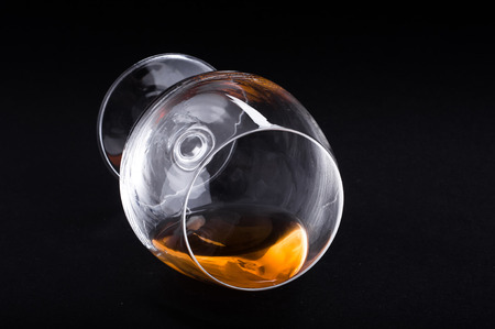 Photo of cognac in glass against black backgroundの写真素材