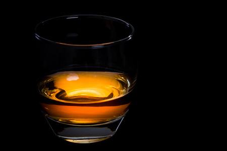 Photo of whisky glass against black backgroundの写真素材