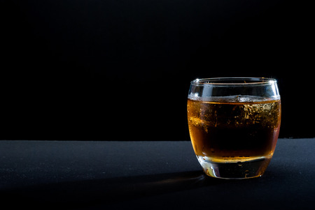 whiskey glass against black backgroundの写真素材