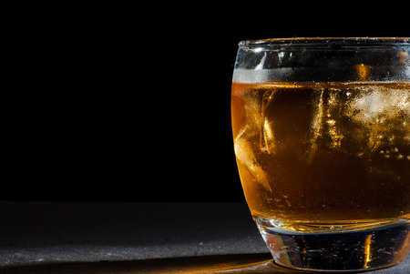 whiskey glass against black backgroundの写真素材