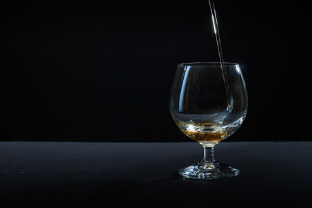 cognac in glass against black backgroundの写真素材