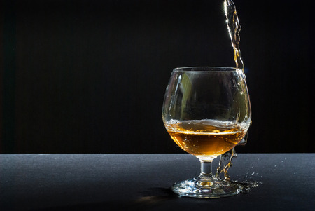 cognac in glass against black backgroundの写真素材