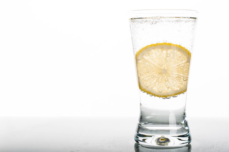 Photo of glass of water with lemon slice on white backgroundの写真素材