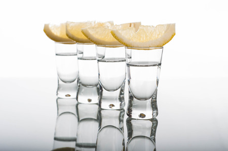 Photo of four shots of vodka with lemonの写真素材