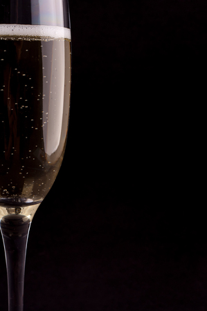 Photo of a glass of champagne on black backgroundの写真素材
