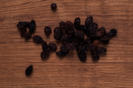 photo of raisins on brown wooden tableの写真素材