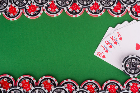 photo of top view of green casino table with royal flush, red and black chipsの写真素材