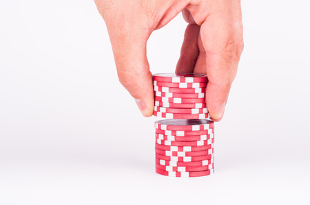 photo of Human hand takeing red casino chips isolated on whiteの写真素材