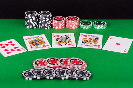 photo of green casino table with royal flush, red and black chipsの写真素材