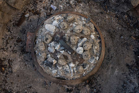 Photo of Cooking traditional dalmatian, croatian, bosnian dish called peka. Meat, potatoes and vegetables in pot and covered with hot charcoal and ash. Balkan food.の写真素材