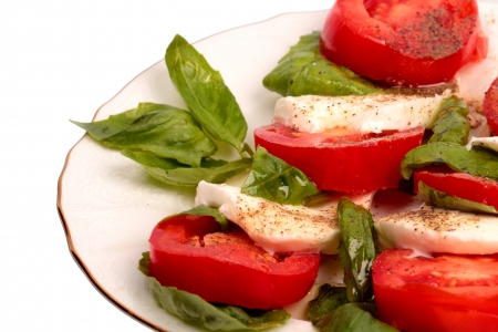 Mozzarella with tomatoes and basil leaves isolated on white backgroundの写真素材