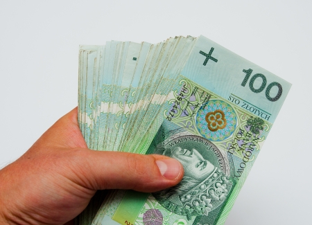 A lot of polish zloty banknotes held in male handsの写真素材