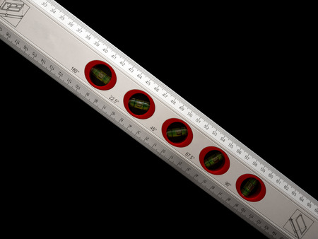 Cut-out of a spirit level. Black background. Concepts of accuracy and technic.