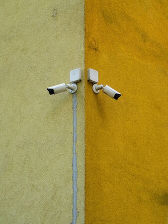 Two cameras of the monitoring system. Cameras placed on the corner of the building. Control and monitoring system. Bright, dirty background.の写真素材
