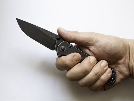 Hand holding a pocket knife. Survival themes, accessories, tools.