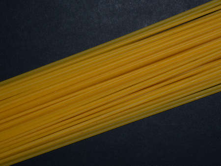 Raw spaghetti. Pasta arranged in a geometric pattern on a black background. Menu concept. Background...