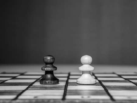 Black and white photo of two chess pieces standing on the chessboard.の写真素材