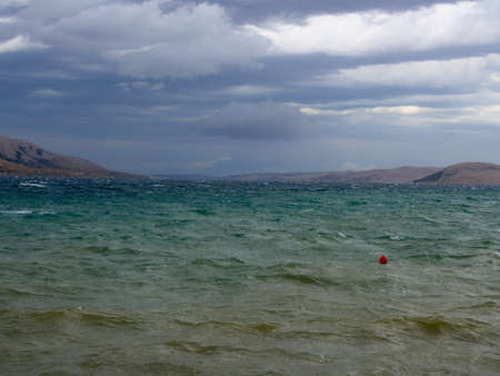 Stormy weather, rocky shore in the background.の写真素材