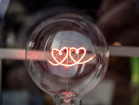 A closeup shot of a light bulb with a heart shape inside