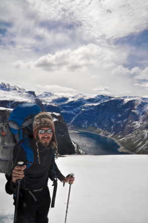 Backpacker on the way to Trolltunga rock with the fjord in the background, Norwayのeditorial素材