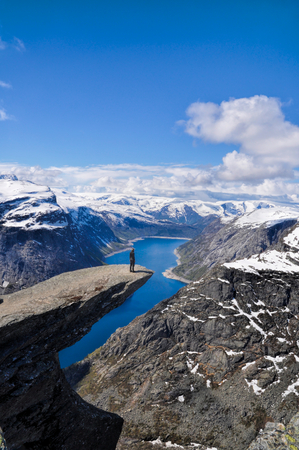 Hiker gazing at nature around Trolltunga rock in Norwayの写真素材