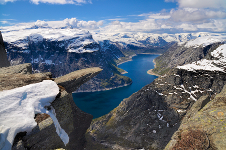 Panoramic view of Trolltunga and the surrounding mountains covered in snowの写真素材
