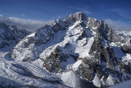 Close-up view of a high mountain covered in snow illuminated by the setting sunの写真素材