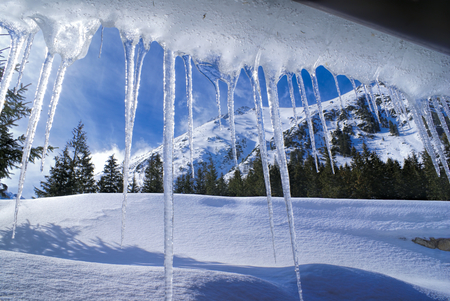 Breathtaking view of Slovak mountains behind huge iciclesの写真素材