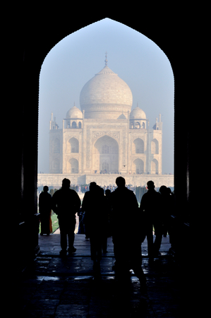 Picturesque view of people standing under an arch looking at Taj Mahalの写真素材