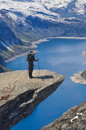 Hiker taking a break at the top of Trolltunga rock in Norwayのeditorial素材