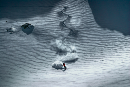 Amazing view of a skier riding down the pisteの写真素材