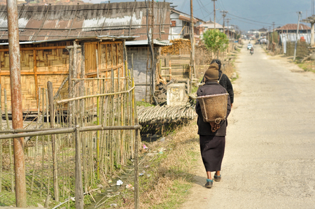 People walking along the street in a poor quarter in Arunachal Pradesh, Indiaの写真素材