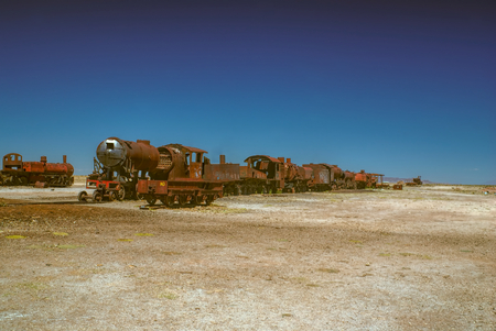 Old locomotive graveyard in desert near Salar de Uyuni in Boliviaの写真素材