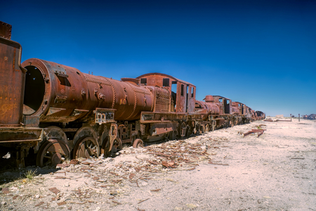 Old locomotive graveyard in desert near Salar de Uyuni in Boliviaの写真素材