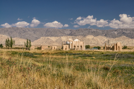 Scenic ruins of ancient temple on green grasslands in Kyrgyzstanの写真素材