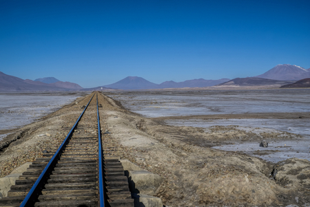 Rail tracks in desert covered by white salt in Salar de Uyuni in Boliviaの写真素材