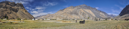 Scenic panorama of remote village with grain fields in Tajikistan on sunny dayの写真素材