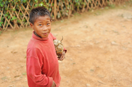 Nagaland, India - March 2012: Small footballer with hand-made ball in Nagaland, remote region of India. Documentary editorial.のeditorial素材