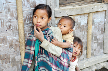 Nagaland, India - March 2012: Small girl with younger brother and sister in Nagaland, remote region of India. Documentary editorial.のeditorial素材