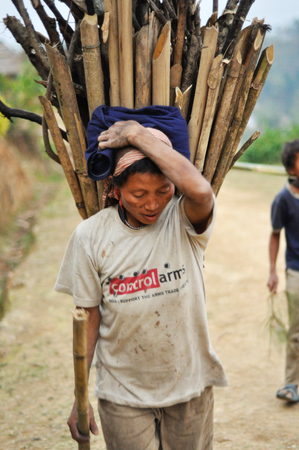 Nagaland, India - March 2012: Young woman carries heavy load in Nagaland, remote region of India. Documentary editorial.のeditorial素材
