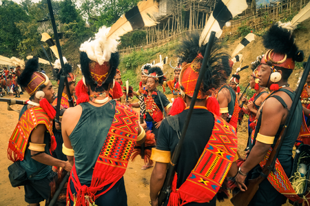 Mon, Nagaland - April 2012: Native men in traditional costumes and large hats stand in circle and dance at Aoleang festival in Mon, Nagaland. Documentary editorial.のeditorial素材