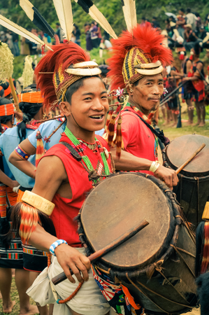 Mon, Nagaland - April 2012: Young boys in traditional costumes play drums during performance at Aoleang festival in Mon, Nagaland. This festival showcases rich cultural heritage of this country. Documentary editorial.のeditorial素材