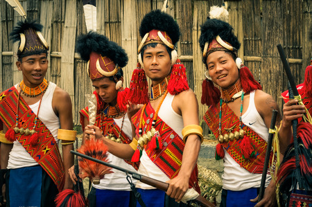 Mon, Nagaland - April 2012: Young boys in costumes and hats made of fur stand in row and smile at Aoleang festival in Mon, Nagaland. This festival showcases rich cultural heritage of this country. Documentary editorial.のeditorial素材