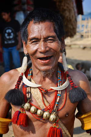 Aoleang, Nagaland, India - April 2012: Native man in traditional headhunting costume smiling at camera during Aoleang festival in Aoleang, Nagaland, India. Documentary editorial.のeditorial素材