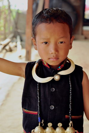 Aoleang, Nagaland, India - April 2012: Small native boy in traditional warrior costume during Aoleang festival in Aoleang, Nagaland, India. Documentary editorial.のeditorial素材