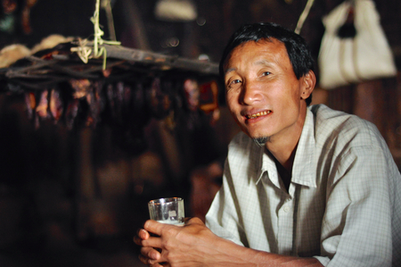 Aoleang, Nagaland, India - April 2012: Young native man holding glass during Aoleang festival in Aoleang, Nagaland, India. Documentary editorial.のeditorial素材