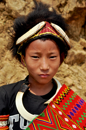 Aoleang, Nagaland, India - April 2012: Young indian boy in traditional warrior costume during Aoleang festival in Aoleang, Nagaland, India. Documentary editorial.のeditorial素材