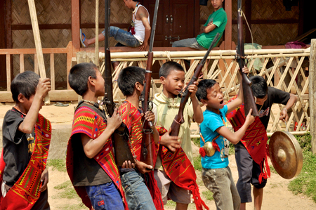 Aoleang, Nagaland, India - April 2012:  Native boys with long rifles dancing on the street during Aoleang festival in Aoleang, Nagaland, India. Documentary editorial.のeditorial素材