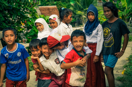 Katupat, Indonesia - June 2015: Native girls and boys stand in row and pose to photocamera in Katupat, Sulawesi, Indonesia. Documentary editorial.のeditorial素材